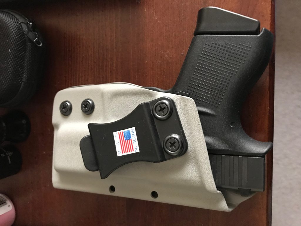 Glock 43 in a carry holster, laying on a dresser top